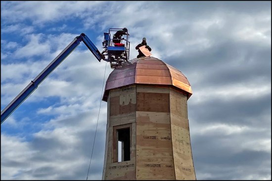 After sheathing and installing ice-and-water shield, workers installed the final copper apron pieces needed to enclosed the roof.