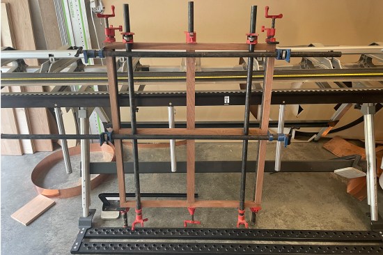 The removable, “closure” muntin frame assembly is secured with pipe clamps on both sides and stood off to the side to dry.