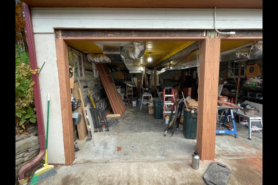 The steel girder was temporarily supported, the center “wall” removed, and the door openings were reconstructed with 2x6 PT stock. A built-up center support post was made out of several laminations of 2x6s and the door openings were then trimmed out with 1-inch-thick sapele.