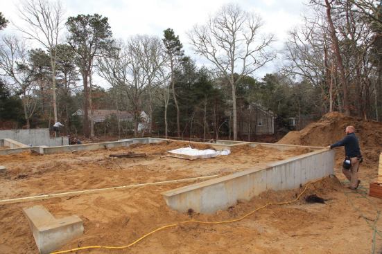 As had been the case earlier, pulling parallel measurements along the front of the house—where the foundation height was consistent—was easy. To make the process go more quickly, we refastened the mudsill for the garage sidewall using the line we'd just snapped.