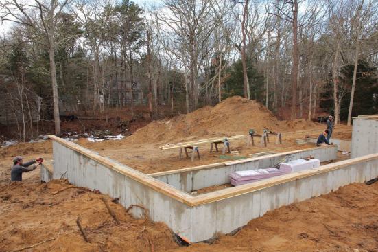We had used the original reference line along the walk-out wall to lay out the rear wall of the rectangle, so we just needed to lay out the two perpendicular walls. As with the garage, I used a mobile-phone app to get the diagonal measurement to locate the two outside corners.