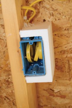 A foam Energy Block provides an efficient way to seal all the little holes in an electrical box. Before installing the drywall, the author will apply a thick bead of caulk to the stud and the block’s wide forward-facing edge to seal the outlet perimeter.