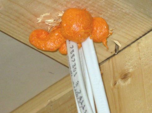 All wire penetrations through framing next to unconditioned spaces must be sealed before drywall. This applies to penetrations in exterior walls as well as interior partitions.