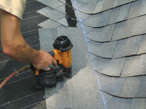 Next, full shingles are nailed end-to-end along a chalk line; a bead of roofing mastic adds insurance against uplift.