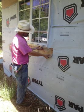 The nails were removed from the bottom flange of each window and flashing was slid behind the flanges.