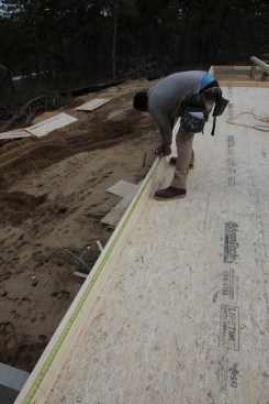 Last to be laid out are the studs. Here a crew member pulls the layout from the end of the wall and marks every stud, including those that fall in the openings for the doors and windows.