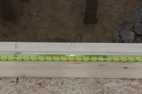 To make the studs line up 16 inches on-center, the layout is marked 3/4 inch (or half the thickness of a 2-by stud) to one side of the highlighted mark on the measuring tape.