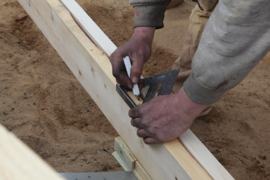 Marking multiples (as for the framing on either side of the garage door) is easy with a layout square. First line up the edge with side of the rough opening and then mark the next two members in the center of the square.
