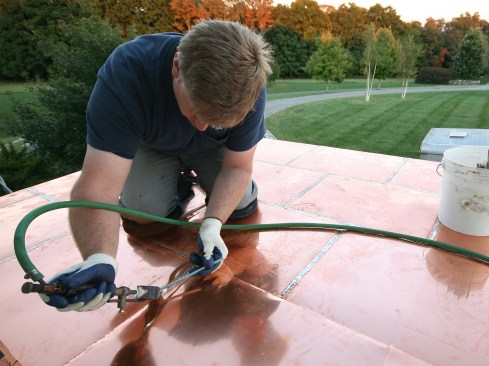 Once we had a few rows locked in and flattened, we began soldering the seams. A rule of thumb is to only install as much copper as you can solder in a day. If it’s going to rain, you want to make sure you get all the installed panels soldered, even dew can affect the solder’s ability to get sucked back into the seam. For this job, we waited for a window of consecutive days of clear weather. We got a little more than half the roof done the first day, then tarped it off at night.