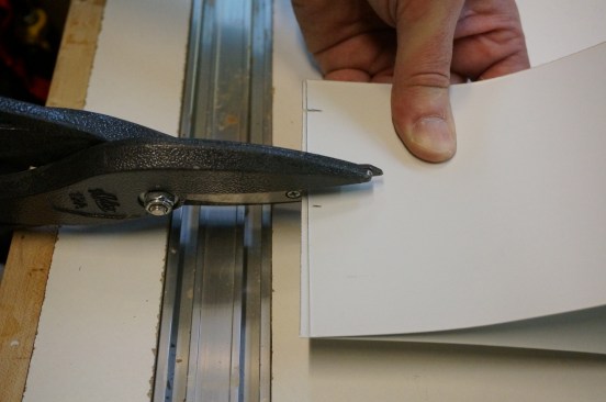 Short slits with tin snips register the dimensions on both ends of the stock.