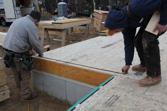 With the largest rectangle snapped out, measure off the established lines for the plate layout of the smaller rectangles. Here, the crew measures off the parallel line at one end...