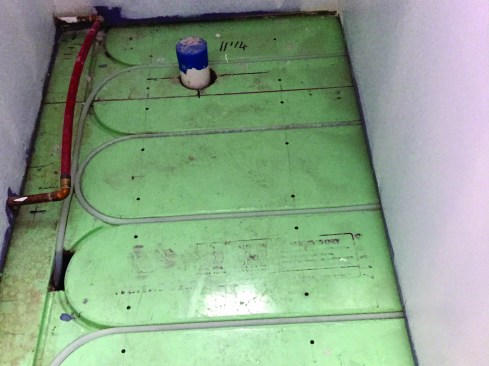 PEX supply and return lines connect to the manifold in the cellar via “bury point” holes in the WarmBoard.