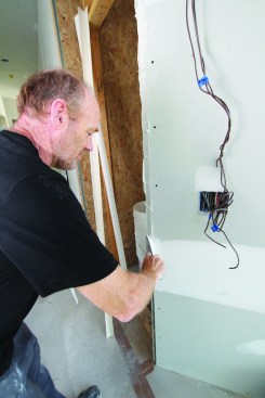 The author applies a deep fill of joint compound to shape the corner.