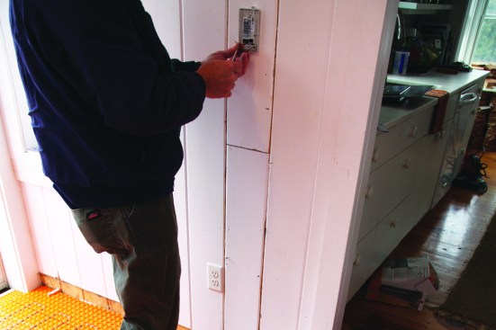 After testing the continuity of the heat mat and setting the sensors, the electrician wires the system to the house panel.