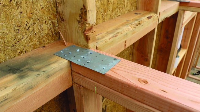 The author balloon frames gable-end walls and installs 4-by fire blocking for easy nailing of the tight edge nailing required for the shear panel (above).