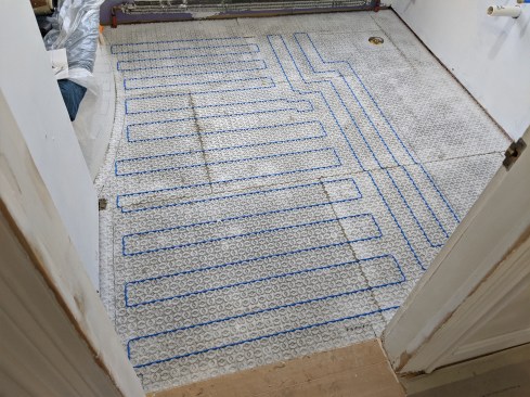 The Laticrete Strata Heat mat is thinset to Laticrete Hydro Ban board, the Hydro Ban acts as a thermal break. Heat wire is laid out serpentine-style on the mat’s pegs per the manufacturer’s recommendations (above).