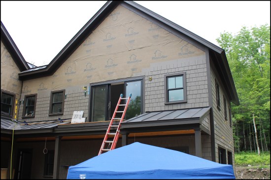 After the general contractor installed the Boral trim, the shingle panels were applied starting on garage wall façade (opposite façade on the right). The installers clad the house clockwise, lining up the coursing around corners and eventually finishing up back at the garage façade.