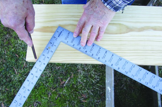 Holding the square with the 6-inch mark on the tongue and the 12-inch mark on the blade lined up with the edge of the lumber, scribe the plumb cuts using the 6-inch side and the level cuts with the 12-inch side. For greater accuracy, multiply the sides by 2 and make a plywood rafter jig with a fence, as shown in the illustration, “Laying Out the Cuts”, above and in the “rafter jig” photos below.