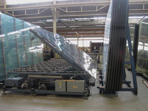 Huge sheets of glass are set down flat and fed into a CNC machine where they are cut to order for a specific project.