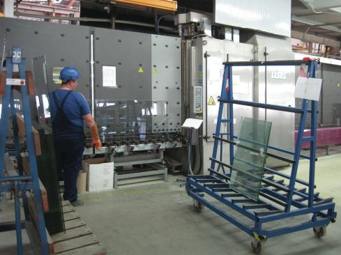Panes of glass are fed into a cleaning machine.