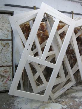 Frames hang on a rack to dry after receiving coats of sealant.