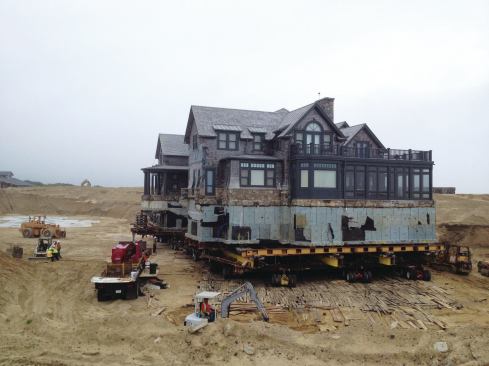 The main house was lifted onto dollies using hundreds of 20-ton bottle jacks while shoring up the slab and footing with thousands of 6x6 oak cribbing timbers. Once free of the ground, the structure was slowly rolled northward on a temporary roadway hardened with 8x12-foot plates of 1/2-inch steel.