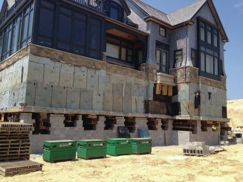 At its new site, the main house was positioned over a reinforced slab. Block walls were built up around the steel lifting beams. The gap between the new block sub-basement and the original footing was filled with non-shrinking grout. 

