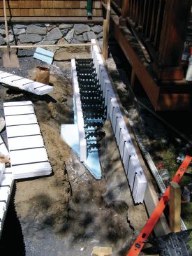 Because parts of the foundation would have to conform to irregular ledge exposed in the excavation, we chose a snap-together ICF form. This allowed us to cut the outer and inner panels separately to fit the contour before we snapped the two panels together with plastic ties.