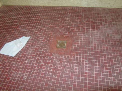 Once the drain assembly was put back together, we water-tested it for 24 hours before the tile guys repaired the area, using a trendy square drain that the clients preferred over the previous round one. The existing grout had a bit of white buildup on it, so the new grout will look darker for the time being. We expect that over time it will match as the same minerals and soaps wash over it. The grout below the surface was the same color as the new grout we used.