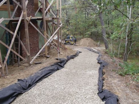  After excavating down about 18 inches and digging trenches across the driveway every 10 feet for drainage, we covered the whole thing with a nonwoven landscape filter fabric and 12 inches of 3/4-inch washed stone.