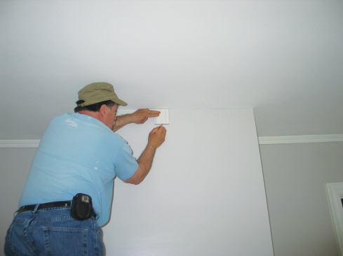 I mark the bottom of the crown profile on the wall using a scrap that I cut exactly 3 15/16 inches long. 