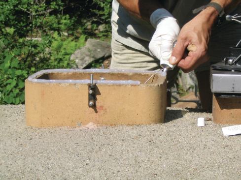 Apply a generous bead of adhesive sealant to the top edge of the liner. Note the angle brackets, which I like to use to bolt the frame to the flue liner.