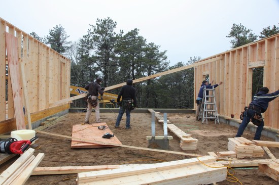 To brace the garage wall plumb, 2-bys are nailed together to form a long diagonal brace that extends to the framing on the other side of the garage.