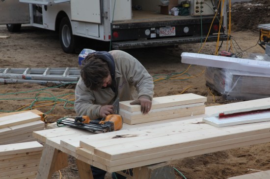 All headers are built before wall framing begins. For 2x6 walls, headers are made from three layers of 2-by material with a layer of 1-inch foam. Here the crew member squares the material before nailing it together.