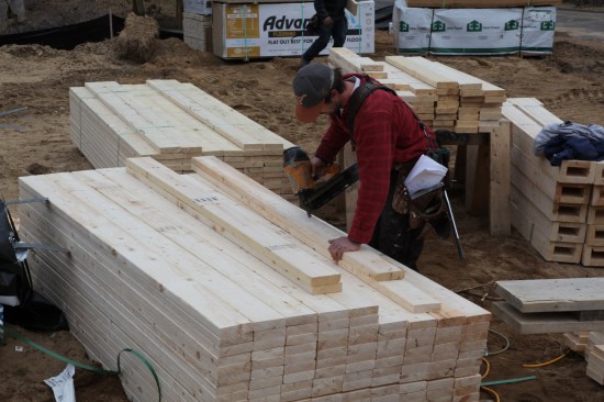 After cutting the jacks (trimmers), a crew member nails them onto full-length king studs.