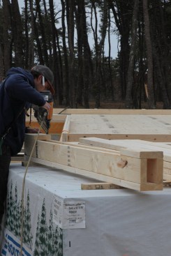 Corners are pre-assembled in a U-Shape with scrap blocks nailed on to keep the legs of the "U" spread while the wall framing is nailed together.