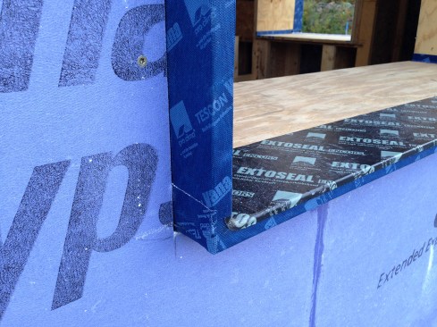 Figure 15. We used Extoseal Encors waterproofing tape to create sill pans for the window. Here, 5/8-inch-thick Gold Bond EXP sheathing by National Gypsum was fit around the window buck. Later, high-performance R-7 windows from PVC Industries were installed toward the outside edge of the window bucks, attached with metal mounting clips.