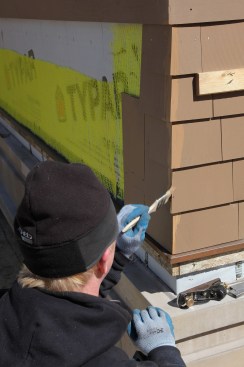 To get an exact color match, the bare wood is covered with stain provided by the shingle manufacturer.