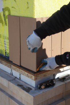 For the corner shingle on the adjacent wall, hold the shingle in place and scribe along the edge of the first shingle. Trim it to fit as before and then nail it into place.