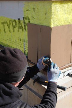 The first corner shingle for the outer layer is scribed and attached. The edge is smoothed with a block plane kept flat against adjacent shingle.