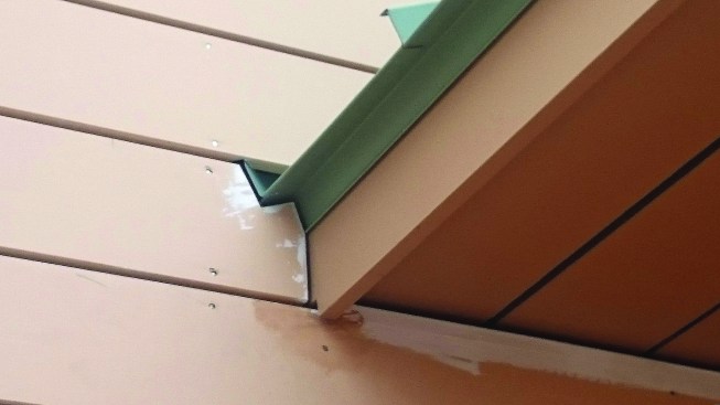 Where roof planes intersect with a side wall, the vertical part of the roof flashing integrates with the drainage plane of the wall. At the bottom of the flashing, a kickout flashing diverts water away from the siding.