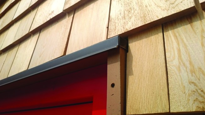 Window cap flashing folds in to properly divert water on a micro scale.