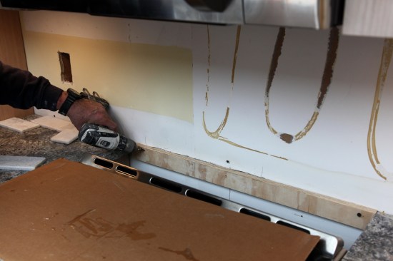 The first step is adding a ledger behind the stove where the tile doesn't have the countertop for support. The ledger comes out after the installation.