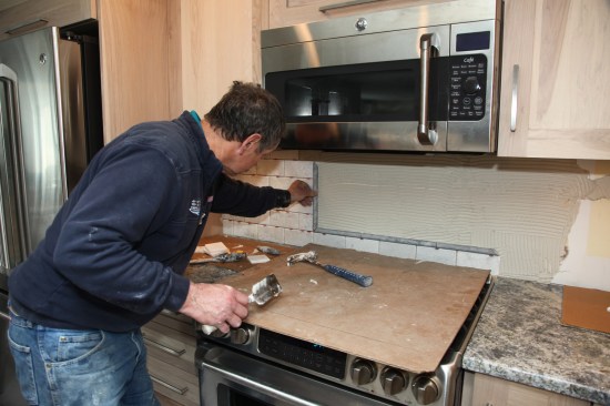 Author installs the mural taking the pieces directly from the dry layout that he had done earlier.