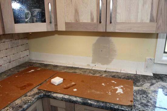 Tile layout for this wall begins with a full tile at the window casing, where the tile will be the most visible. Odd size tiles aren't nearly as noticeable in the corner under the cabinets. 