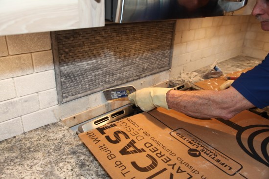 A narrow grout trowel is handy for hard-to-reach places, such as under the mural and behind the sink.