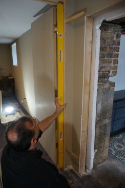 Plumb the hinge jamb and insert shims at the bottom hinge as well.