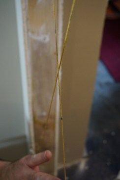 If the sides of the opening are in the same plane, the strings should barely touch where they cross. If the strings are not touching, adjust the framing in or out until the opening is plumb and the strings are touching.