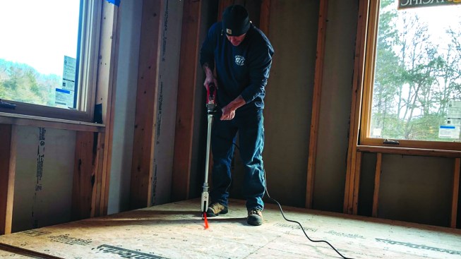 After tacking the sheets in place, one crew member screwed the subfloor layers together with an auto-feed screw gun, driving more than 12,000 screws.
