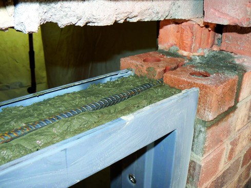 After filling the head channel about two-thirds of the way, he embeds rebar in the mix.